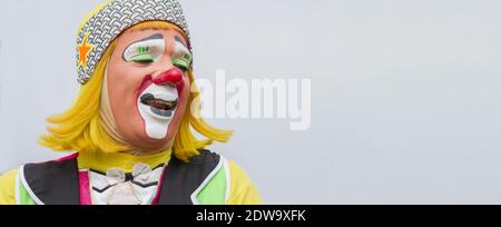 Happy Clown isoliert Porträt lateinamerikanisch freudig Durchführung und lächeln Mit glücklichen Gesicht tragen bunte Kostüm, rote Nase, gelbe Haare und Lackiert Stockfoto