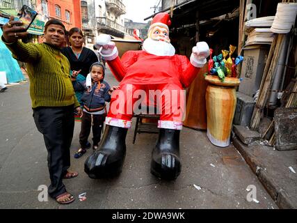 Kalkutta, Indien. Dezember 2020. Menschen machen ein Selfie vor einem riesigen Bildnis von Santa Clause. Kredit: SOPA Images Limited/Alamy Live Nachrichten Stockfoto