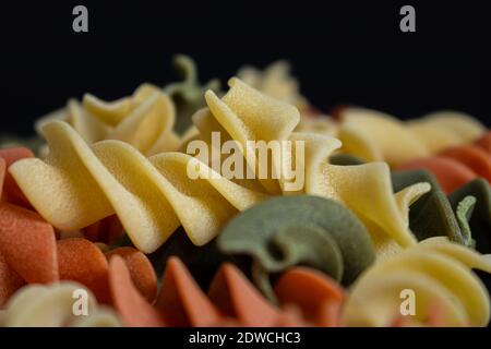 Dreifarbige italienische Pasta auf schwarzer Oberfläche. Stockfoto