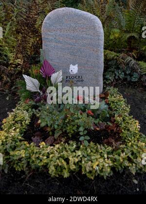 Hamburg, Deutschland. Dezember 2020. Das Grab eines Hundes namens Flocki ist auf dem Ohlsdorfer Friedhof mit Blumen geschmückt. Seit März können Meister und Mätressen zusammen mit ihren Tieren im Osten des Friedhofs begraben werden. Die ersten Tiere haben dort bereits ihre letzte Ruhestätte gefunden. Quelle: Axel Heimken/dpa/Alamy Live News Stockfoto