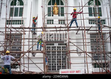 21.12.2020, Singapur, Republik Singapur, Asien - nach Abschluss der Renovierungsarbeiten demontiert eine Gruppe von Bauarbeitern ein Holzgerüst. Stockfoto