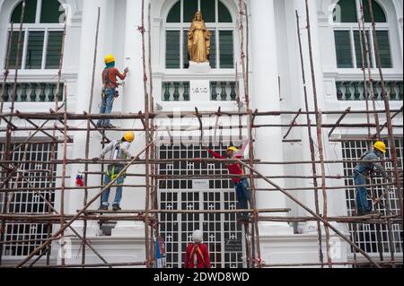 21.12.2020, Singapur, Republik Singapur, Asien - nach Abschluss der Renovierungsarbeiten demontiert eine Gruppe von Bauarbeitern ein Holzgerüst. Stockfoto