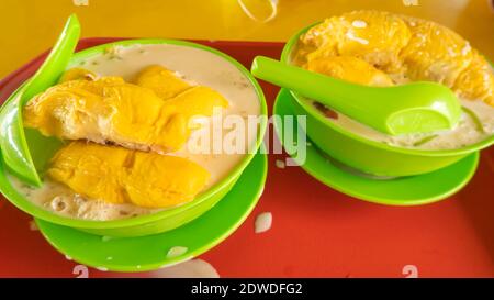 'Durian Cendol' ist ein süßes, eisgekühltes Dessert, das Tropfen aus würmchendem grünem Reismehl, Kokosmilch und Palmzucker-Sirup mit Durian fru enthält Stockfoto