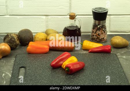 Frische Paprika auf dem Tisch. Orange gelb rote Paprika auf dem Tisch als Hintergrund und Ort für Text.frisches Bio-Gemüse auf einem hellen Holz t Stockfoto