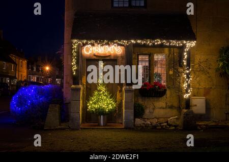 Weihnachtsdekorationen in der Nacht vor einem Cottage am Broadway. Cotswolds, Gloucestershire, England Stockfoto