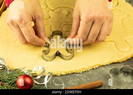 Extrudieren aus Mürbeteig mit einer Metallform. Verwöhnen Sie Ihre Familie und Ihre Lieben mit eigenen Händen. Ausstechformen aus Metall Stockfoto