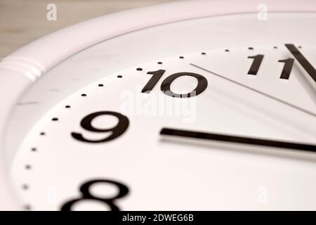 Zifferblatt einer analogen Uhr Nahaufnahme. Zeit 08:55 Uhr. Weißes Zifferblatt, schwarze Ziffern. Stockfoto