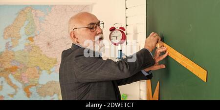 Lehrer des höheren Mannes verwenden Lineal beim Zeichnen. Tutor Mann in Brille zieht mit Lineal auf die Tafel. Zurück zur Schule. Welcher Winkel Sie sehen. Geometrische Formen. Moderne Ausbildung in der High School. Stockfoto