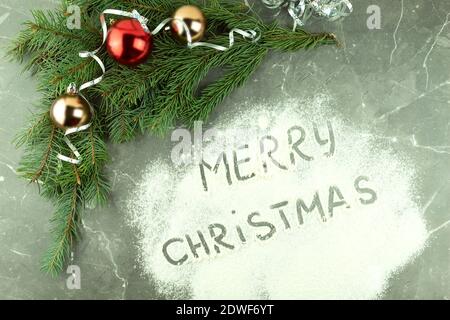 Weihnachtshintergrund mit Text Frohe Weihnachten auf weißem Hintergrund. Text auf Mehl bestreut Stockfoto