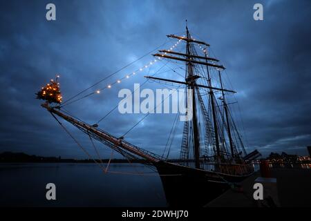 Rostock, Deutschland. Dezember 2020. Zu Weihnachten mit einem Weihnachtsbaum auf dem Jib-Boom geschmückt, liegt das traditionelle Segelschiff 'Santa Barbara Anna' im Stadthafen. Urlauber und Touristen sind an der Ostsee nicht mehr erlaubt seit Beginn der zweiten Sperre feiern die Hanseaten Weihnachten und Silvester zu Hause und untereinander. Quelle: Bernd Wüstneck/dpa-Zentralbild/ZB/dpa/Alamy Live News Stockfoto