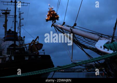 Rostock, Deutschland. Dezember 2020. Zu Weihnachten mit einem Weihnachtsbaum auf dem Jib-Boom geschmückt, liegt das traditionelle Segelschiff 'Santa Barbara Anna' im Stadthafen. Urlauber und Touristen sind an der Ostsee nicht mehr erlaubt seit Beginn der zweiten Sperre feiern die Hanseaten Weihnachten und Silvester zu Hause und untereinander. Quelle: Bernd Wüstneck/dpa-Zentralbild/ZB/dpa/Alamy Live News Stockfoto