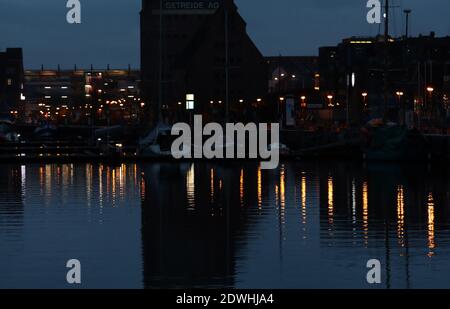 Rostock, Deutschland. Dezember 2020. Die Lichter werden am frühen Morgen im Wasser im Stadthafen reflektiert. Urlauber und Touristen sind an der Ostsee nicht mehr erlaubt seit Beginn der zweiten Sperre feiern die Hanseaten Weihnachten und Silvester zu Hause und untereinander. Quelle: Bernd Wüstneck/dpa-Zentralbild/ZB/dpa/Alamy Live News Stockfoto