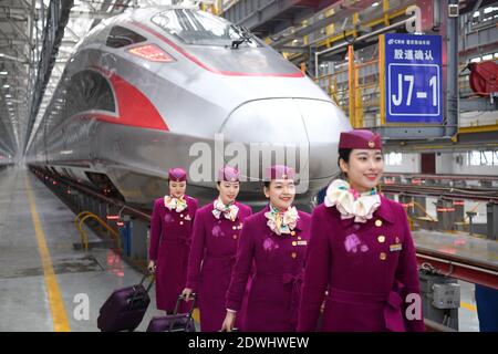 (201223) -- CHONGQING, 23. Dezember 2020 (Xinhua) -- Besatzungsmitglieder der ersten Operation des Fuxing-Hochgeschwindigkeitszuges CR400AF posieren für Fotos vor dem Zug an einer Wartungsstation des Eisenbahnwaggons-Depots in der westchinesischen Gemeinde Chongqing, 23. Dezember 2020. Der Fuxing-Hochgeschwindigkeitszug CR400AF, der erstmals der Chongqing Railway zugewiesen wurde, debütierte am Mittwoch in Chongqing und wird voraussichtlich am Donnerstag mit dem Dienst vom Bahnhof Shapingba in Chongqing zum Bahnhof Chengdu East in Chengdu in der westchinesischen Provinz Sichuan in Betrieb gehen. Die Fahrt zwischen den beiden Städten wird von 78 Minuten verkürzt Stockfoto