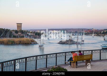 Ägypten, Oberägypten, Assuan, Paar sitzen auf der Bank im Fryal Garden und Blick auf den Nil Stockfoto