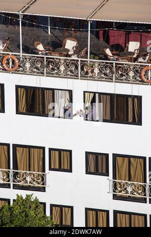 Ägypten, Oberägypten, Assuan, zwei Männer, die Fenster auf Nilkreuzern putzen Stockfoto