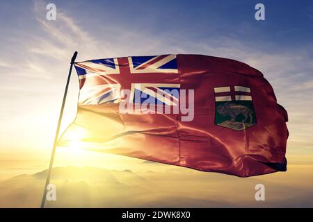 Manitoba Provinz von Kanada Flagge winken auf der Spitze Sonnenaufgang Nebelnebel Stockfoto