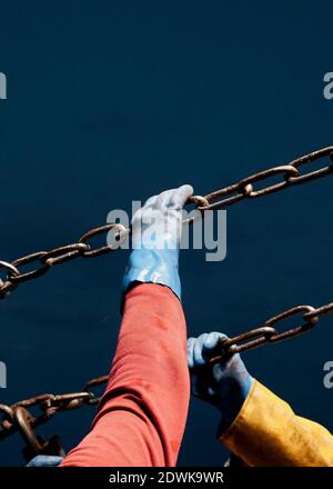 Trawlernetze werden vom Heck des Bootes in der Nacht ins Meer geführt. Stockfoto