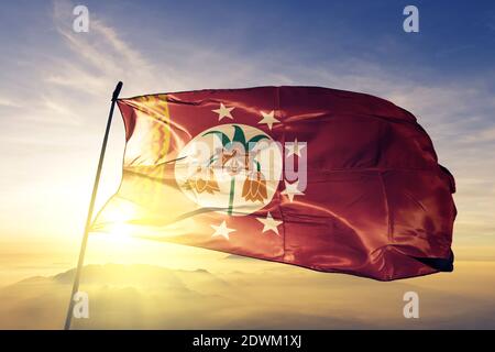 Batken Region Oblast Kirgisistan Flagge winkt auf der Spitze nebel bei sonnenaufgang Stockfoto