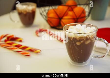 Weihnachten oder Neujahr gemütliche Komposition, Hintergrund. Eine Tasse Kaffee, Mandarinen auf einem weißen Tisch. Weiche Farben Stockfoto