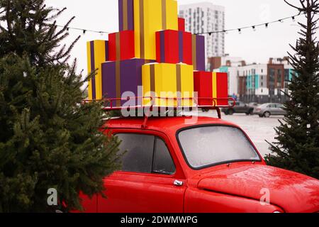 Weihnachten rot Retro Auto mit Geschenk-Boxen, weihnachtsbaum draußen Stockfoto