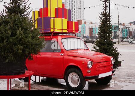 Weihnachten rot Retro Auto mit Geschenk-Boxen, weihnachtsbaum draußen Stockfoto