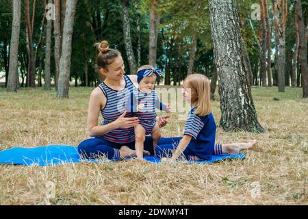 Sicheres Fitnessstudio oder Fitnesscenter im Freien. Familie durch gemeinsames Training in Parks fit bleiben. Mutter praktiziert Yoga mit ihrem Baby Tottdler Tochter in der Stockfoto