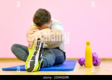 Portrait eines Fitness-Mannes, der Stretching-Übungen im Fitnessstudio macht. Hochwertige Fotos Stockfoto