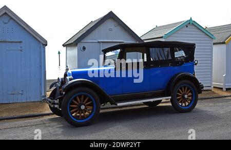 Vintage Overland Willys Whippet Tourer Auto an der Strandpromenade vor Strandhütten geparkt. Stockfoto