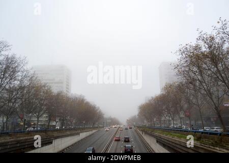 Neblige Landschaft auf der Plaza Castilla in Madrid. Sie können die schlechte Sicht aufgrund der Wolken, die die Straßen wie Paseo de la Castellana bedecken sehen. Hori Stockfoto