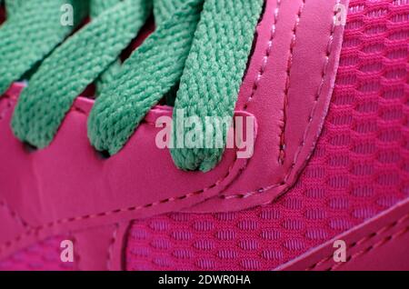 Nahaufnahme der neuen rosa Sportschuhe mit grünen Schnürsenkeln Stockfoto