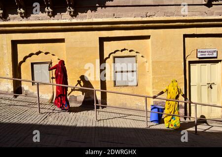 Jodhpur, Rajasthan, Indien - Dezember, 2016: Zwei Frauen in traditionellen indischen Tuch fegen den Hof von Meherangarh Fort Stockfoto