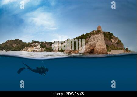 Halb unter und über Wasser Foto von Taucher schwimmen unter Wasser mit alten römischen Tempelruinen in der Ferne. Baiae, Pozzuoli, Neapel. Italien Stockfoto