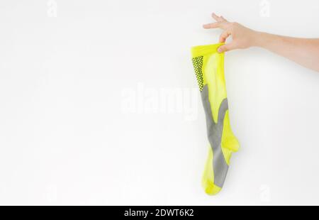 Stinkende gelbe Laufsocke in der Hand auf hellem Hintergrund Stockfoto