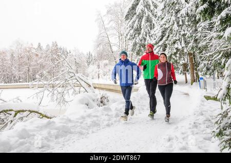 Junge Leute joggen im verschneiten Park Stockfoto