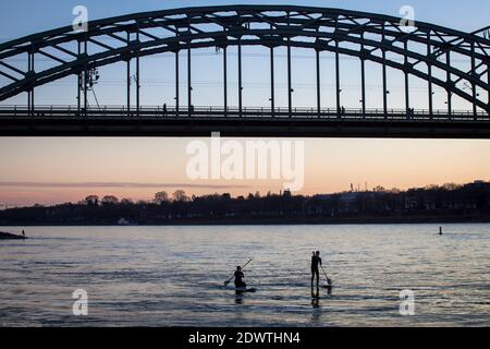 Die Südbrücke, Eisenbahnbrücke über den Rhein, Stand-up-Paddler, Köln, Deutschland. Die Südbrücke, Eisenbahnbrücke über den Rhein, Stand Stockfoto