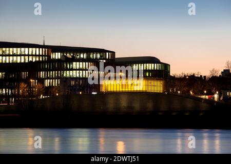 Blick über den Rhein zum Bürogebäude Köln Oval Büros und dem gelb beleuchteten Hochwasserpumpwerk im Stadtteil Bayenthal, Colo Stockfoto