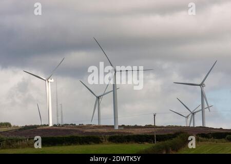 Sonnendurchflutete Windkraftanlage, Sonnenlicht auf einzelne weiße Windkraftanlage umgeben von anderen Windkraftanlagen auf Hügel erneuerbare Energie Windpark. Stockfoto