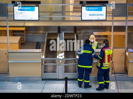 Greven, Deutschland. Dezember 2020. Zwei Mitarbeiterinnen und Mitarbeiter des Technischen Hilfswerks (THW) stehen am Meldeschalter der Impfstelle des Landkreises Steinfurt im Terminal am Flughafen Münster-Osnabrück. Hier startete ein Testlauf im Impfzentrum mit rund 50 Testpersonen aus THW, DLRG, Malteser, DRK Kreisverband ST und DRK Kreisverband TE. Quelle: Guido Kirchner/dpa/Alamy Live News Stockfoto