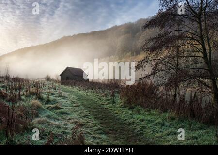 Bootshaus an einem nebelbedeckten Fluss Wye in Brockweir. Stockfoto