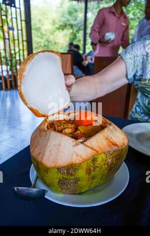 Eine Mahlzeit in einem kambodschanischen Restaurant mit Fleisch und Gemüse in einer ausgehöhlten Kokosnussschale, Kambodscha, Asien Stockfoto