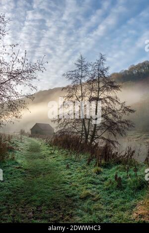 Bootshaus an einem nebelbedeckten Fluss Wye in Brockweir. Stockfoto