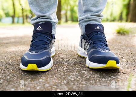 UKRAINE, ZAPOROZHYE - MAI 24, 2020 : männliche Füße in blauen Adidas-Schuhe im Freien Stockfoto