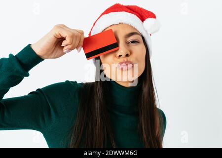 Nette Frau in santa Hut mit Kreditkarte auf weiß Hintergrund Stockfoto