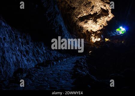 Licht, das durch ein Loch in eine dunkle Höhle eindringt. Beleuchtete Höhle. Exit, Escape, Hope Konzepte Stockfoto