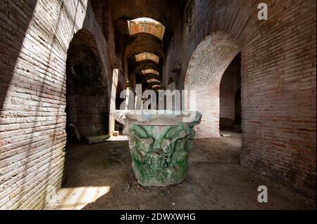 Riesige alte römische Hauptstadt einer Säule, im Inneren des Flavian Amphitheatre. Pozzuoli, Campi Flegrei (Phlegräische Felder), Neapel, Kampanien, Italien Stockfoto