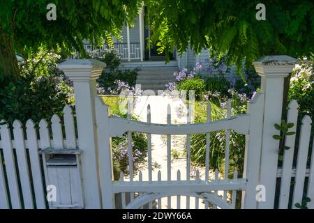 Tor und Pfad, der zur Haustür durch den Garten der alten Welt führt. Stockfoto