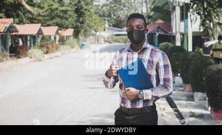 Portrait von afrikanischen Lehrer in Gesichtsmaske im Freien zu stehen Schule Stockfoto