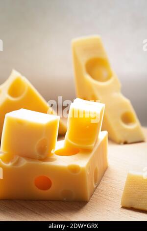 Stücke von frischem gelben Käse, Brocken auf Holztisch. Milchproduktkonzept. Stockfoto