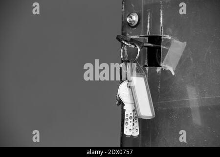 Ein Haufen Schlüssel hing in einer Tür. Türschlüssel zum Öffnen der Eingangstür im Haus. Stockfoto