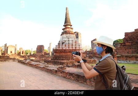 Reisende tragen Gesichtsmaske machen Bilder während des Besuchs im Wat Phra Si Sanphet Tempel inmitten COVID-19, Ayutthaya, Thailand Stockfoto